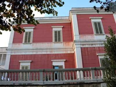 Si sviluppa su quattro piani separati da una cornice aggettante e circondati da finestre caratterizzate da semplici persiane coronate da architravi. Tutti gli elementi strutturali sono di colore bianco e si stagliano su un dominante rosso sbiadito